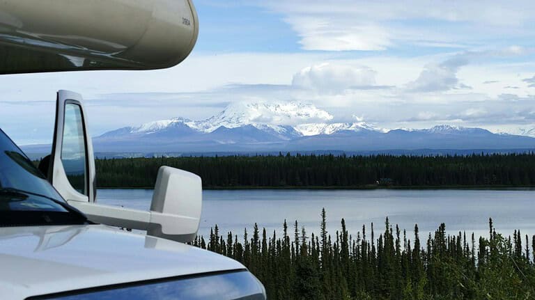 Motorhome beside a lake with mountains beyond